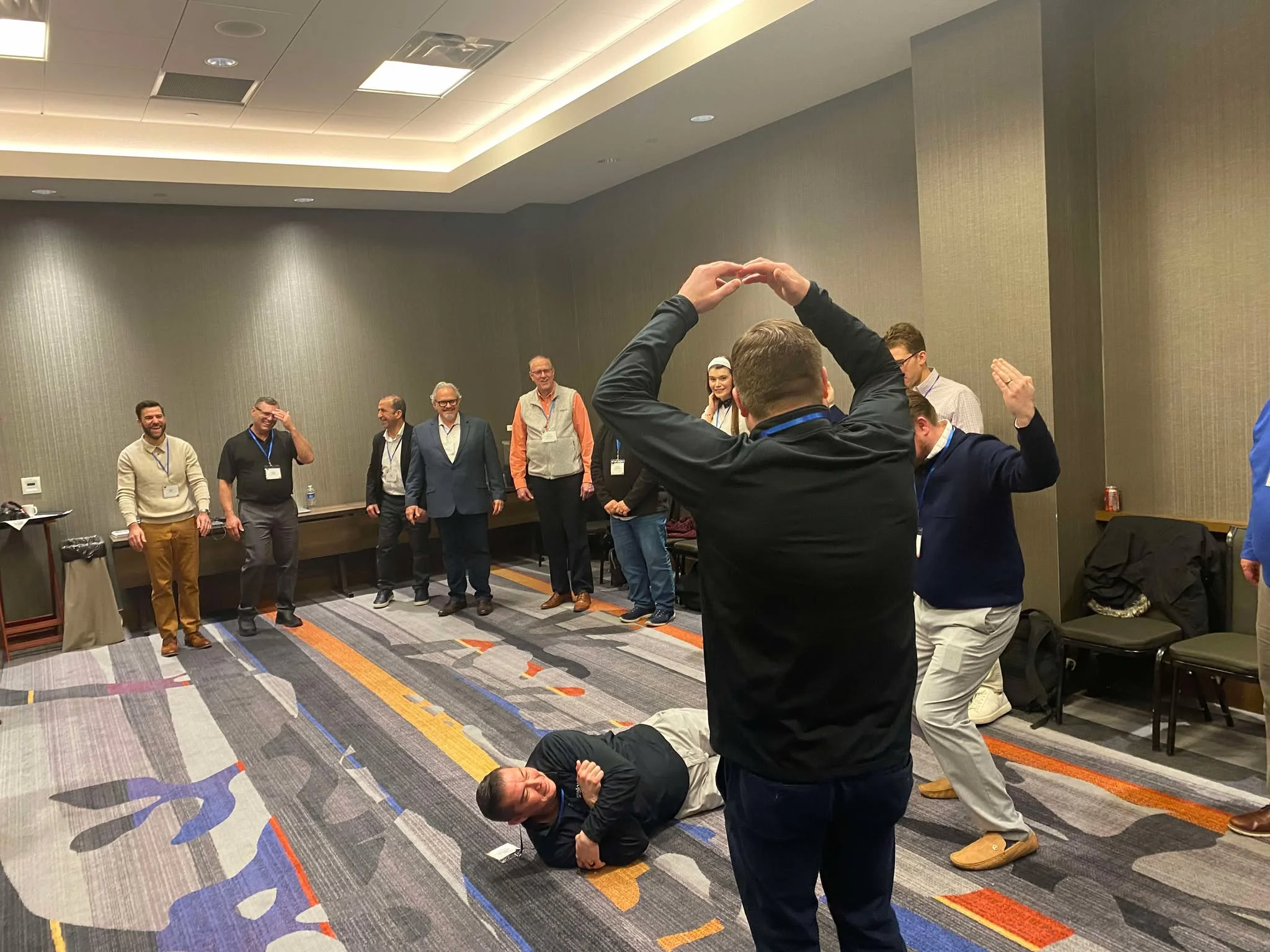 Workshop participants engaged in a dramatic applied improv exercise in a conference room setting